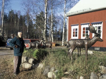 Gunnar Hansson utanför sin bostad bland djuren som han drivit fram i koppar.