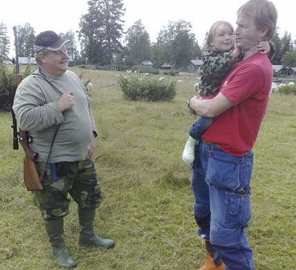 Per Hållnissa med dottern Sandra talar med en av jägarna som bevakade fåren mot nya vargattacker.