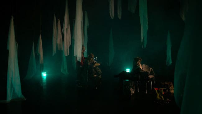 Publiken tågar in i en mörk och stillsam skog, där de slår sig ner kring lägerelden i väntan på att jakten ska börja i föreställningen "Jaktlaget".