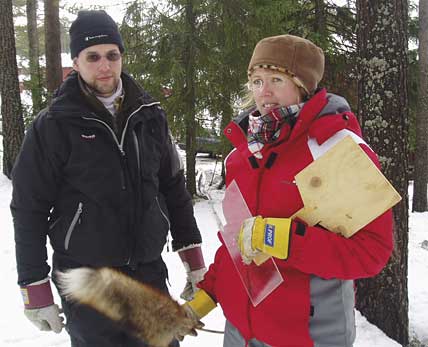 Fredrik Nilsson och Minna Herlin beredda med redskapen som behövs för att snaran ska fånga ett byte i snön.